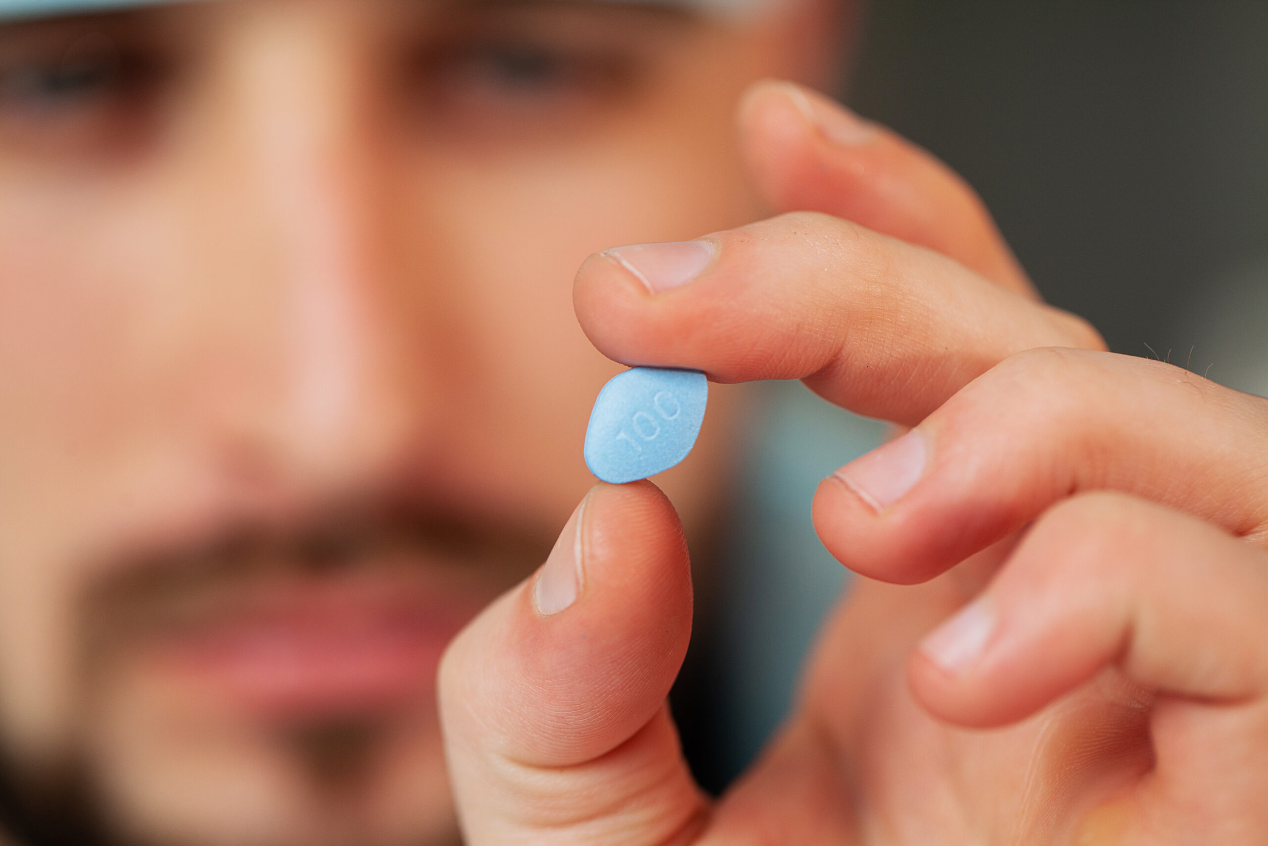 Close up of male doctor holding pill for men health.