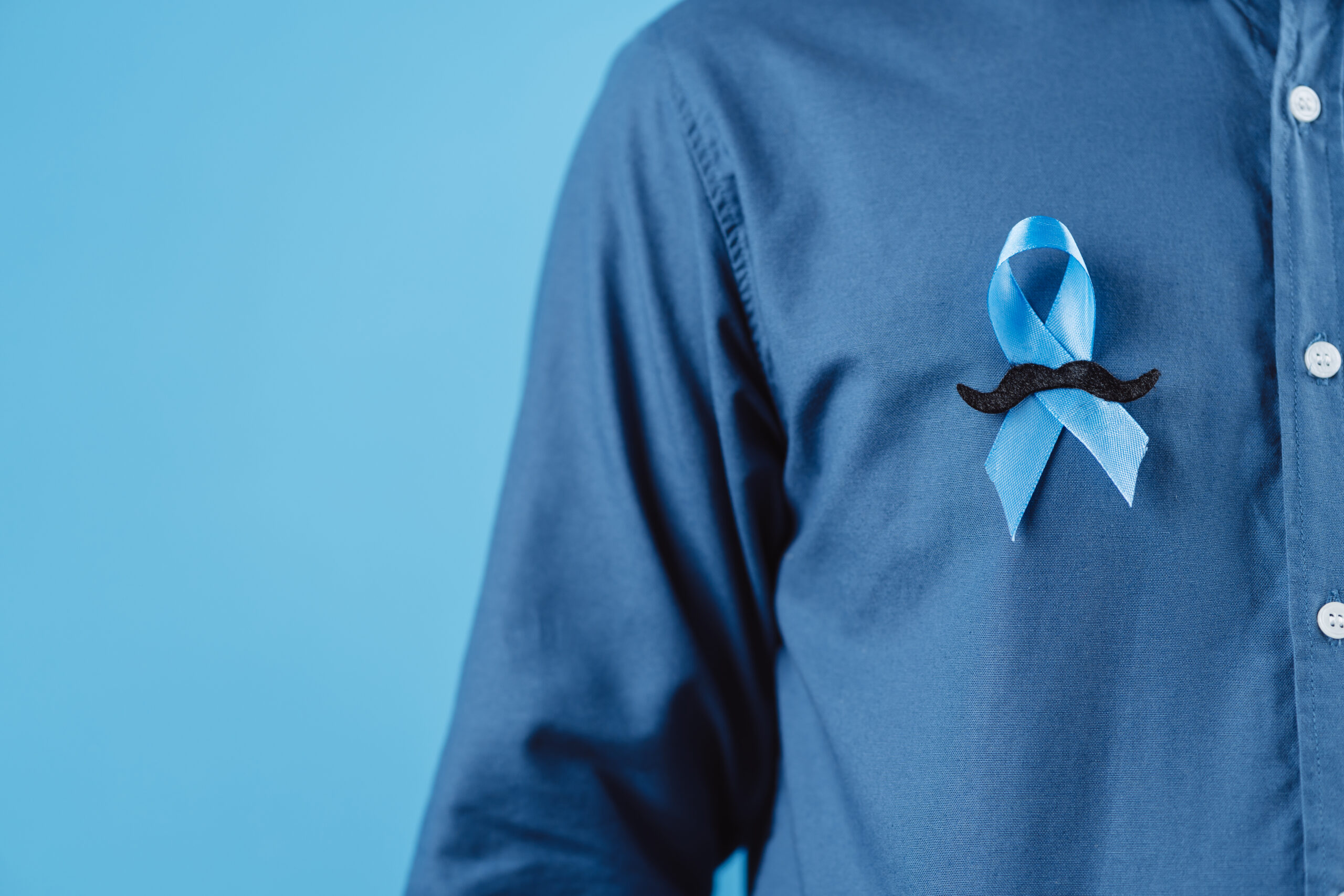men hands showing Blue ribbon with moustache for supporting people living and illness, Colon cancer, Colorectal cancer, Child Abuse awareness, world diabetes day, International Men's Day