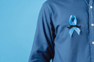 men hands showing Blue ribbon with moustache for supporting people living and illness, Colon cancer, Colorectal cancer, Child Abuse awareness, world diabetes day, International Men's Day