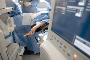 Surgery treatment in progress. Patient lying on the operating table with a pulse oximeter on the finger. Concept of monitoring the patient's condition during surgery